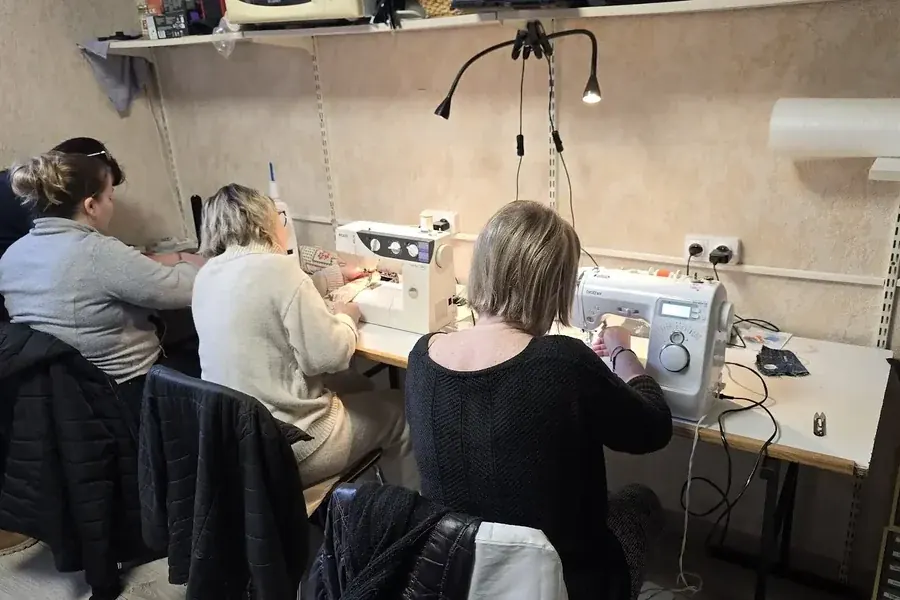 Élèves d'un atelier de couture devant leurs machines à coudre