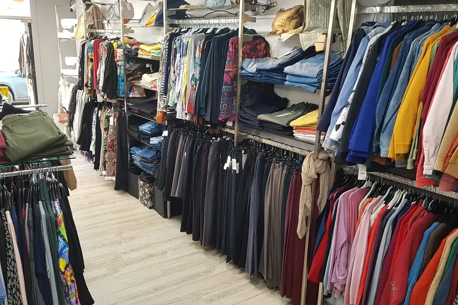 Robes et vestes suspendues aux portants de la boutique